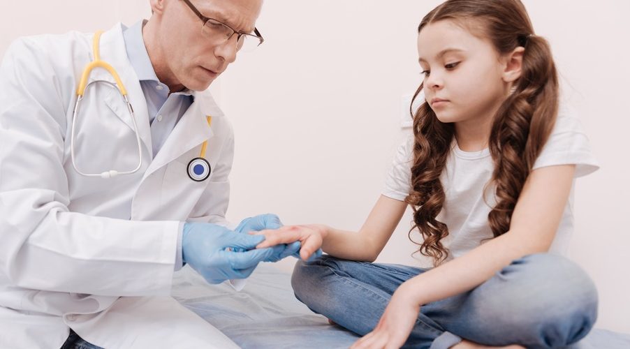 dermatologist examining pediatric patient