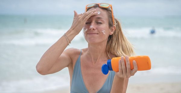 women applying sunscreen on face
